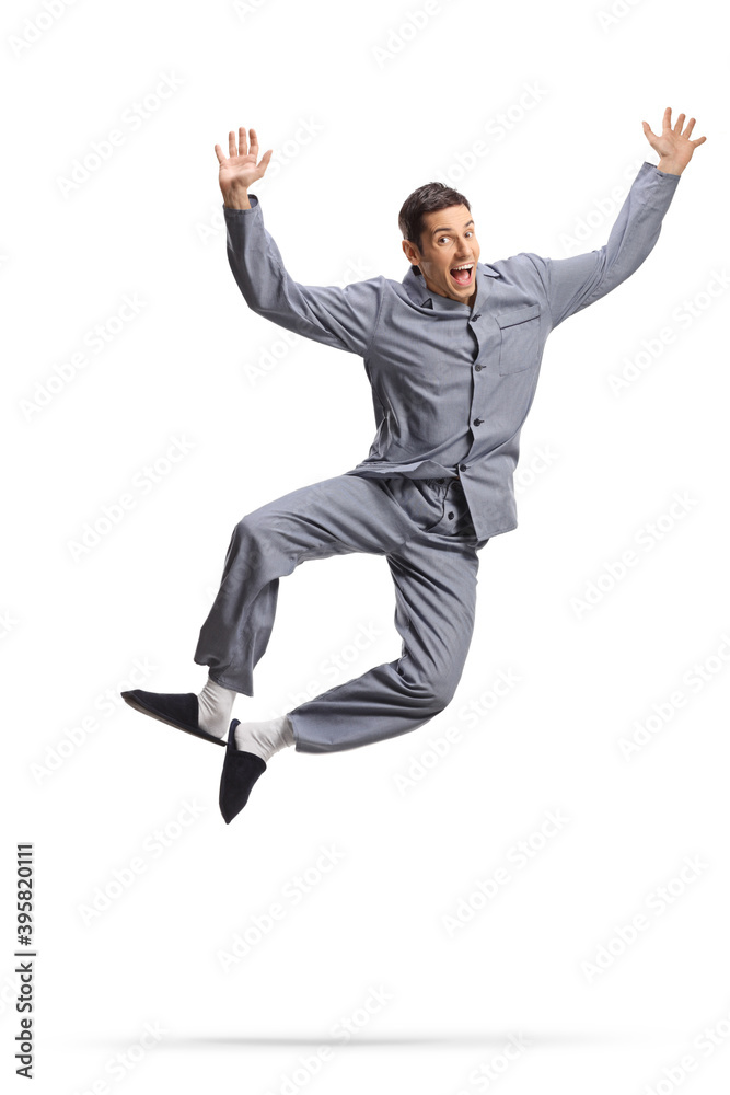 Wall mural young happy man in pajamas jumping