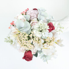 Delicate wedding bouquet in pastel shades from artificial flowers top view close-up. A spare bridal bouquet made of faux flowers from foamiran. Valentine's day greeting card and invitation.