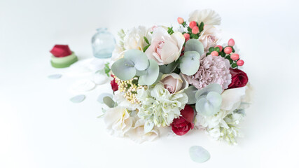 An elegant bouquet of artificial flowers made of foamiran on a pale blue pastel background with copy space. Faux flowers made from plastic and foamiran. Valentine's day greeting card or invitation.