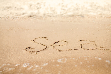 Handwritten Sea Word on the Sand Coast. Wonderful words on beach sand. Love idea concept.