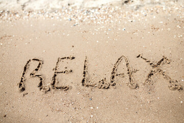 Handwritten Relax Word on the Sand Coast. Wonderful words on beach sand. Love idea concept.