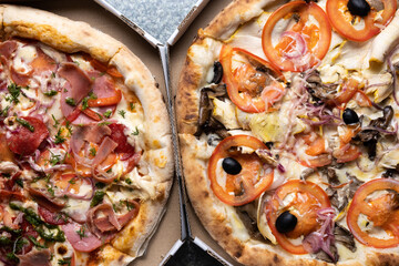 Two different pizzas in a box top view.