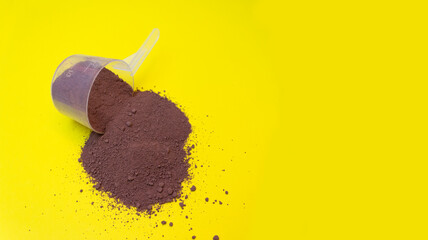 Collagen, chocolate protein scattered on yellow background. Protein nutrition in sports
