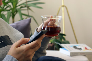 Woman using mobile phone while sitting on sofa