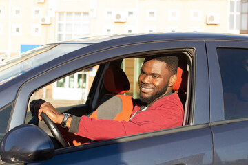 African-American driving a blue car