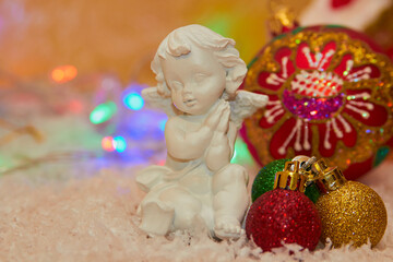 white angel figurine christmas,plaster angel in the snow with Christmas balls decorated