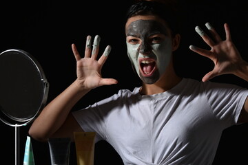 Femme qui fait une grimace avec du masque sur les doigts