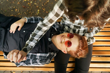 Stylish young couple is spending time together outdoors. Top view of attractive tomboy and cute...