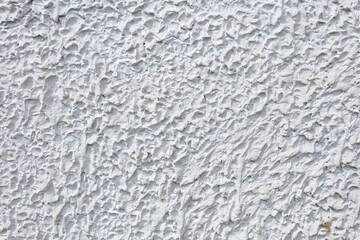 Fragment of a three-dimensional large-relief texture of textured plaster on the exterior of the Foundation of a house outdoor.