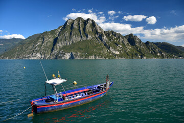 A boat on Lake Iseo, the mountains of Corna Trentapassi on the other side of the lake. Lombardy, Italy.