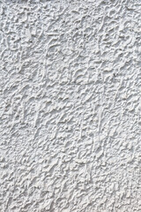 Fragment of a three-dimensional large-relief texture of textured plaster on the exterior of the Foundation of a house outdoor.