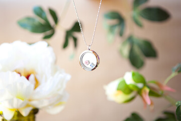 shining Silver necklace for lady on peonies flowers background. Luxury silver jewelry chains with...