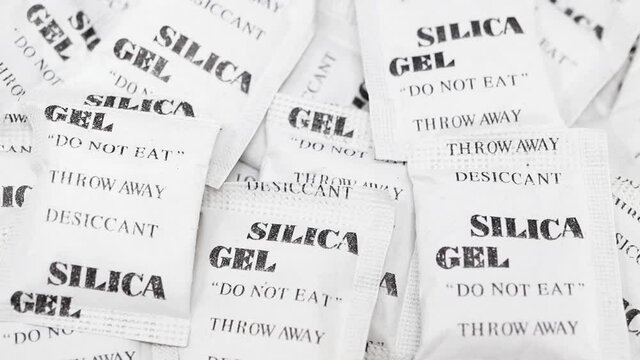 Pile of silica gel packets slowly rotating. Silica gel packets are used to absorb moisture and keep things dry.