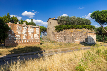 The imposing brick mausoleum, Casal Rotondo Mausoleum, Via Appia Antica Rome, photographed on a day with sun and clouds. Remains of the pavement, maritime pines, the Roman countryside.