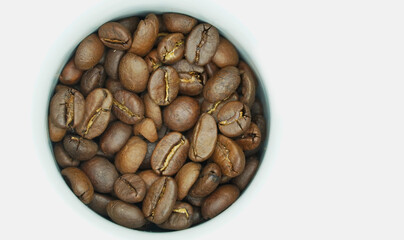 Raw coffee beans in espresso mug on white background