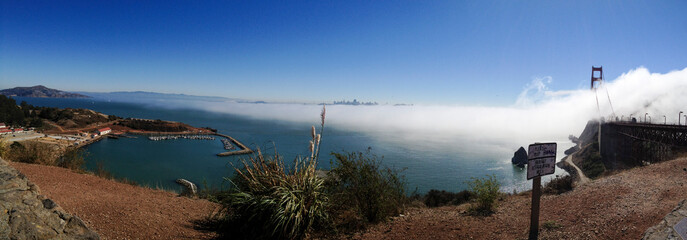 Panoramic shot of Golden Gate Bridge and the San Francisco city next to the bridge.