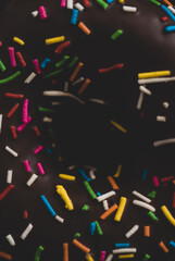Delicious Chocolate Donuts with colorful sprinkles, Black background