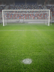 Shallow depth of field (selective focus) image with the penalty kick point on an empty soccer stadium. © MoiraM