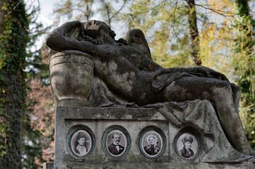 Old photos on the gravestone with woman sculpture at Lychakiv cemetery in Lviv, Ukraine
