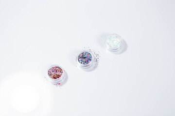 Sequins for nails in a box on a white background. Bright, light. Nail tips collection, salon advertisement.