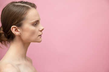 Beautiful sensual topless brunette womanstanding isolated over pink background, posing