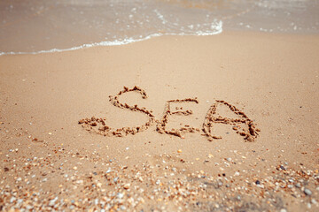 Handwritten Sea Word on the Sand Coast. Wonderful words on beach sand. Love idea concept.
