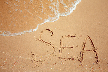 Handwritten Sea Word on the Sand Coast. Wonderful words on beach sand. Love idea concept.