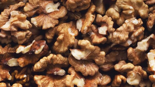 Background and texture of revolving peeled walnuts. View from above.