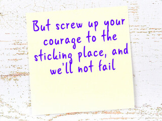 Yellow sticky note on wooden wall with wise quote