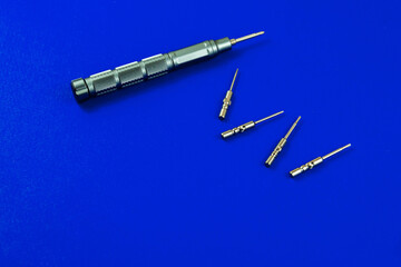 Tools composition, screwdriver with replaceable bits, nozzles, on a blue background close up