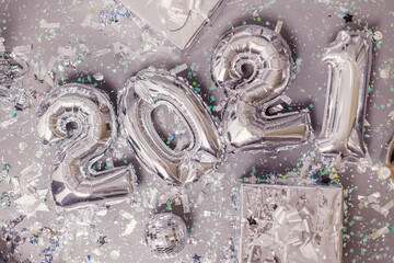 new year 2021 concept. Foil balloons silver metallic shining numbers. Holiday christmas. Party texture background. Serpentine glitter decor. Flat lay top view gifts