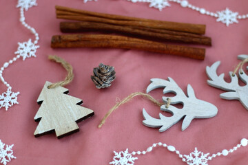 Various Christmas decorations and cinnamon sticks on pink background. Selective focus.