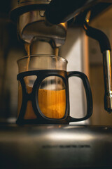 coffee machine making a coffee into glass cup 