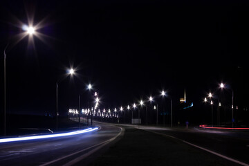 Horizontal landscape photo of a highway at night lighting with street lamps along it 