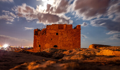 Fototapeta premium Medieval castle on the shores of the Mediterranean Sea in Paphos city on the island of Cyprus in the light of the full moon.