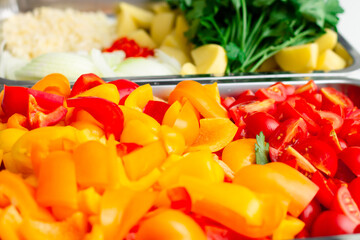 Chopped ingredients for making oriental vegetable stew. Paprika, potatoes, onions, tomatoes, garlic, peppers, spices.