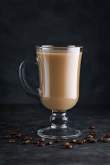 Coffee in a glass Cup with grains on the table.