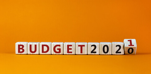 Business concept of starting 2021. Fliped a wooden cube and changes the words 'Budget 2020' to 'Budget 2021'. Beautiful orange background, copy space. New year and budget 2021 concept.