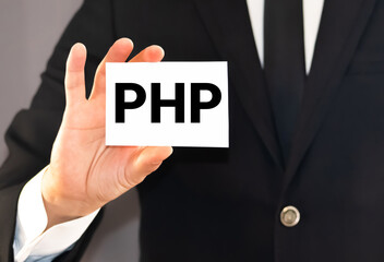 Businessman in blue shirt and gray tie shows a card with the inscription PHP.