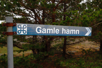 Fototapeta premium Sign post with direction to the old medievial harbor, Gamle hamn, located at the Faro island in the Swedish province of Gotland.