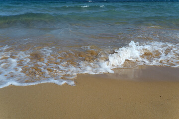 Fototapeta na wymiar Foamy Wave On The Sandy Beach.Beautiful wave on the beach.