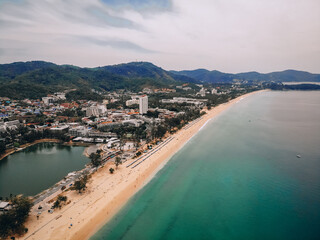 Fototapeta na wymiar Aerial view of the long sandy beach, palms, coastal town with hotels, hills and seashore; exotic country concept.