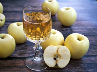 Apple juice and yellow apples fruit on wooden background	