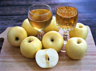Apple juice and yellow apples fruit on wooden background	