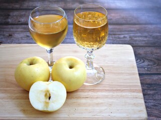 Apple juice and yellow apples fruit on wooden background	