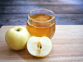 Apple juice and yellow apples fruit on wooden background	