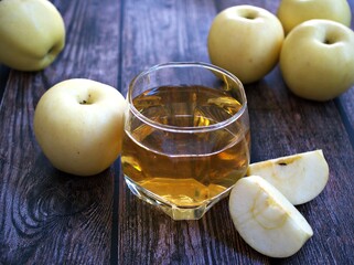 Apple juice and yellow apples fruit on wooden background	