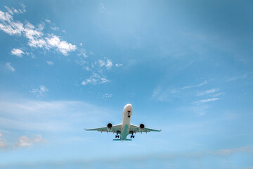White airplane photographed from below is flying in clear blue sky, The fastest way to travel. Time saving