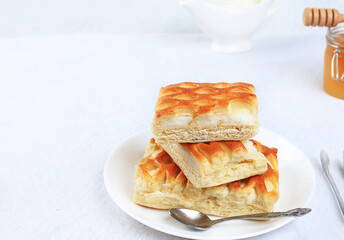 Pies with cottage cheese on a light table with honey and milk, Cheesecakes with wicker dough. Modern bakery concept. Healthy traditional breakfast, selective focus, place for text