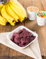 Brazilian Açai on a white square pot with on a wooden background and fruits at summer